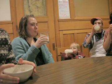 A baby drinking from a bottle fits right in with Tank co-op members drinking milk.
