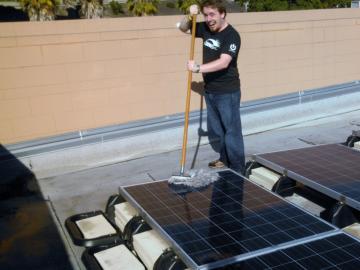 Alex Deeter cleaning a Solar Panel with a mop