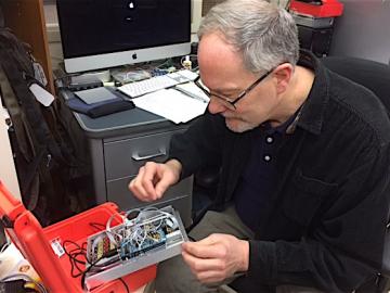 John Talbert inspects wires in an electronic component