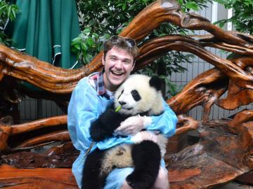 Jacob Myers holds a baby panda