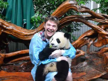 Jacob Myers holds a baby panda
