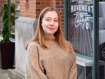 woman in tan sweater smiling.