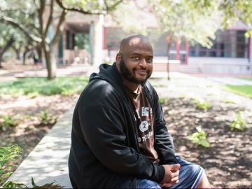 Kiese Laymon seated outdoors.
