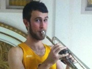 An athlete plays a trumpet