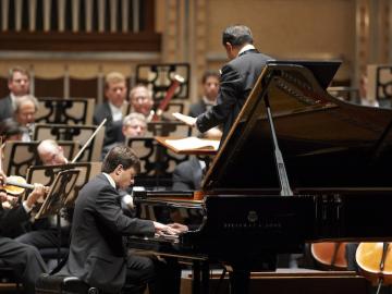 Pianist performs with orchestra.