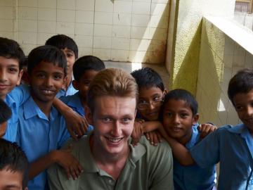 team member and rising junior Thomas Kreek with young students in New Delhi