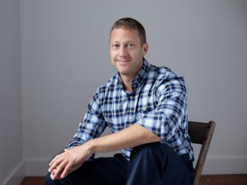 Image of Matthew Bahar sittig in wooden chair.