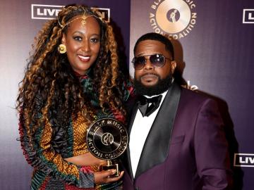 A woman holding an award next to a man in a suit