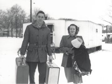military veteran with his wife outside of a trailer during the winter.