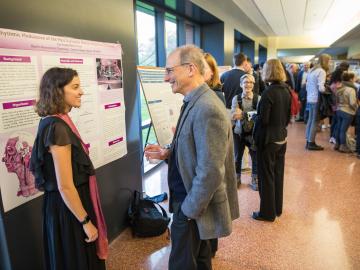 Students present poster board displays in a hallway