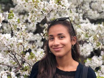 Natalia Garcia smiling in front of a backdrop of flowers