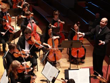 View of orchestra and conductor from behind the stage