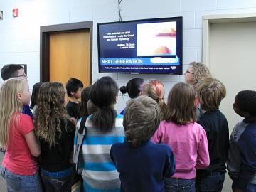group of students looking at a TV