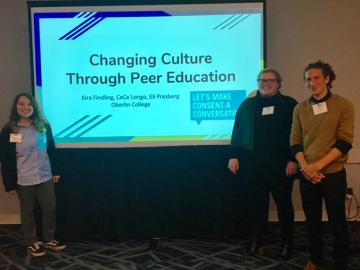 PRSM student trainers standing by large presentation screen