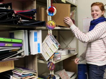 Rosalie Eck places a binder onto a crowded shelf.