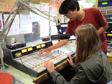 High school students using the soundboard at the WOBC DJ booth