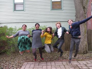 Five Oberlin Shansi fellows holding hands and jumping into the air