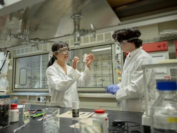 Shuming Chen working with a student in a chemistry lab.