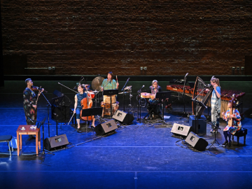 six artists, female and non-binary, onstage playing various instruments