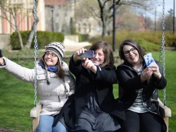 Students sitting on swing next to Finney Chapel.