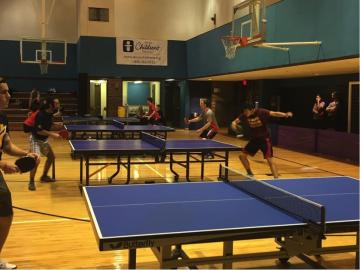Table tennis matches in action on 4 tables.