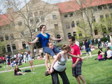 Wilder Bowl filled with people. Acrobats start to climb on top of each other.