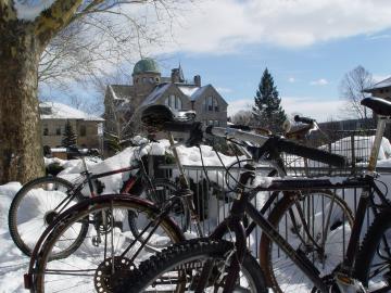 Bicycles on a bike rack, surrounded by snow.