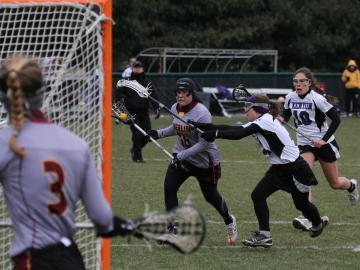 Oberlin womens lacrosse player running towards the opposing net against the Kenyon team