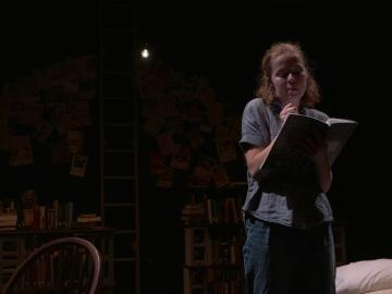 A girl writes in a notebook.