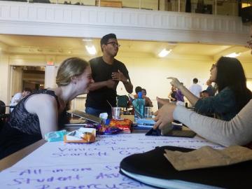 Students talking at a table.