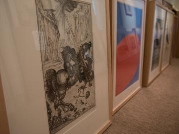A row of prints and paintings on a floor.