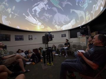 Students look at a astrological symbols in an astronomy class.