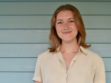 woman smiling with slatted wood background.