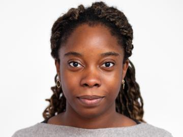 Black woman smiling with white background.