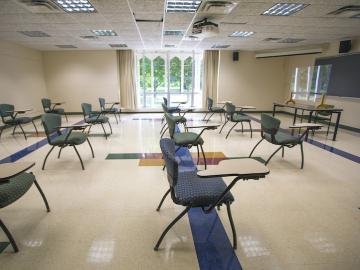 A classroom with desks facing toward a chalkboard.