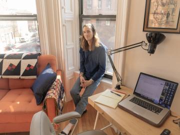 Man sitting next to a computer in his apartment.