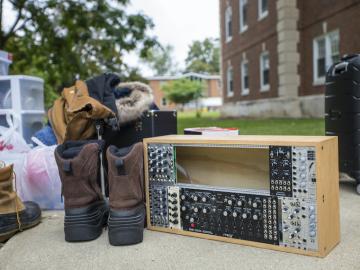 A pair of boots and a soundboard sit on a sidewalk.