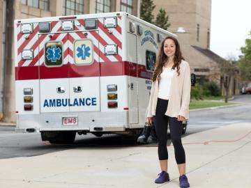 A student standing next to an ambulance