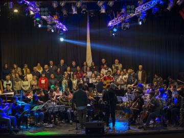 Orquesta Participativa large group of singers and musicians on stage.