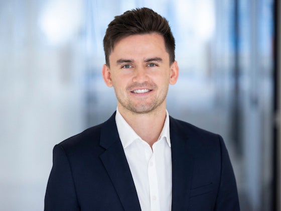 a person wearing a dark blue suit coat and white collared shirt
