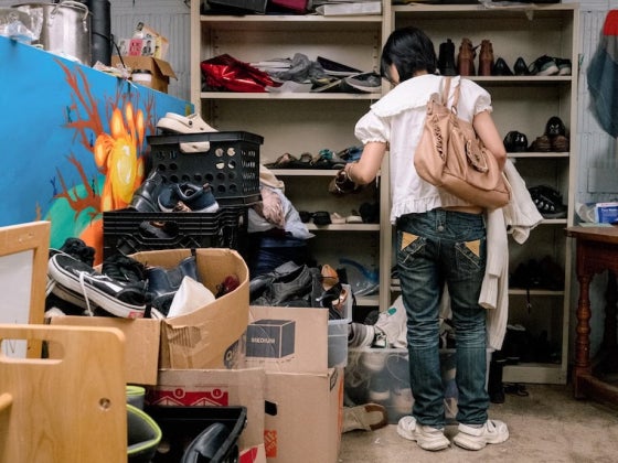A student looks through a room full of clothing and ephemera.