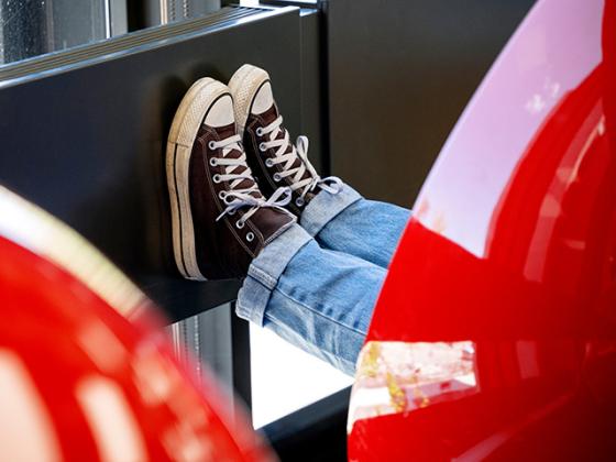 A pair of feet in Converse All-Stars pokes out from the confines of a ball chair.