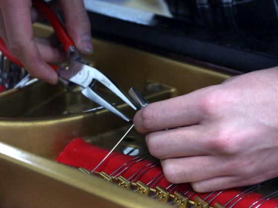 Close-up of hands using needle nose pliers.