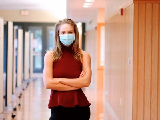 Rochelle van der Merwe stands in a hallway wearing a disposable mask