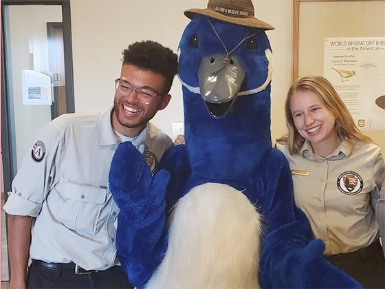 Marcus Hill and another researcher pose with a blue bird mascot