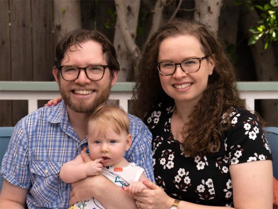 Andy and Siena holding a baby.