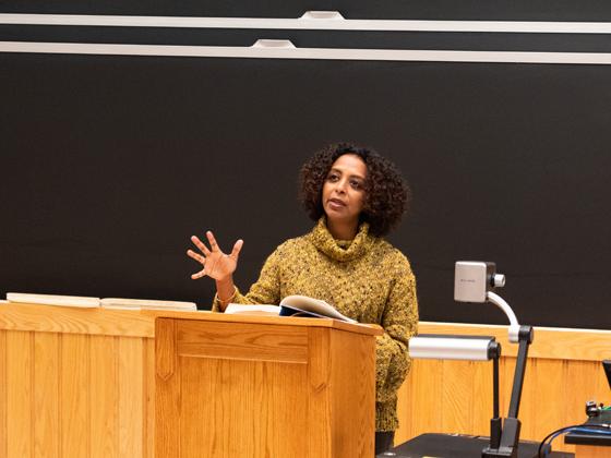 A woman gives a talk at a podium.