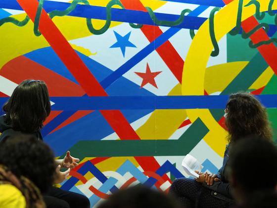 Two students looking at a colorful, primary-color mural.
