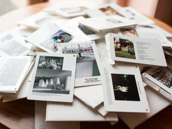 A loose pile of cards, each with a photo of people. Some photos are black & white.