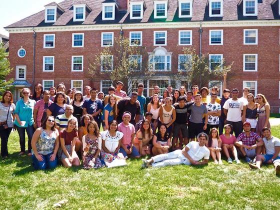 A large group of Latinx students, faculty and staff gathered outside for a picture.